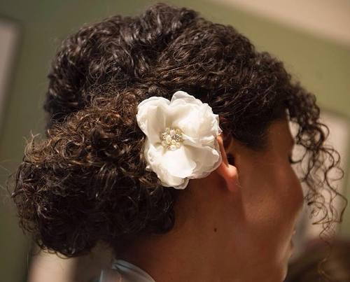 Hochsteckfrisur für natürliches Haar mit einer Blume