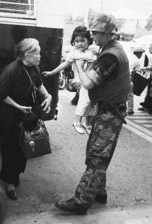 войник carrying little girl