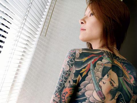 امرأة يابانية مع الوشم تغطي الظهر والذراعين