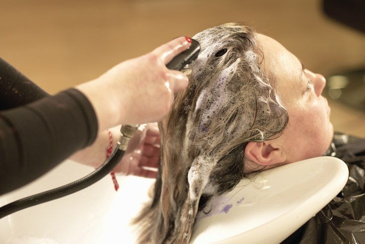 Vlasy stylist washing clients hair