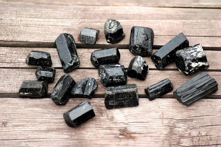 Černá tourmaline quartz pieces on a wooden background