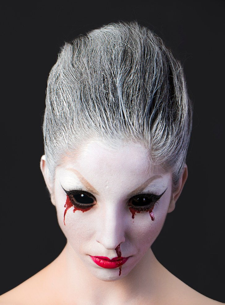 Портрет Of Woman In Geisha Make-Up Against Black Background