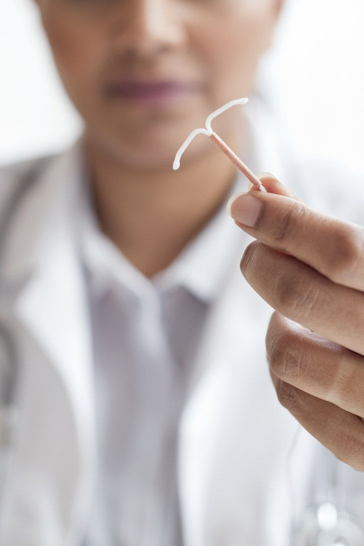 ženský doctor holding an IUD