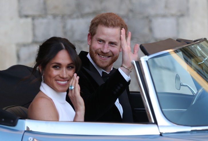 Meghan Markle (wearing her white Stella McCartney reception dress) and Prince Harry leave Windsor Castle after their wedding to attend an evening reception at Frogmore House, hosted by the Prince of Wales on May 19, 2023 in Windsor, England.