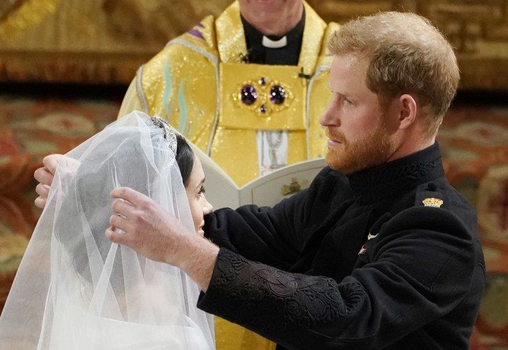 princ Harry lifts the veil of Meghan Markle during their wedding ceremony in St George's Chapel at Windsor Castle on May 19, 2023 in Windsor, England. 
