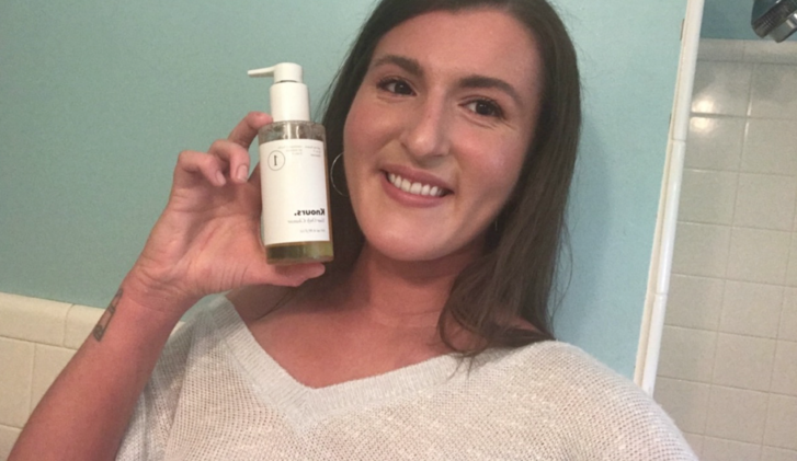 kaleigh holding a bottle of knours cleanser 