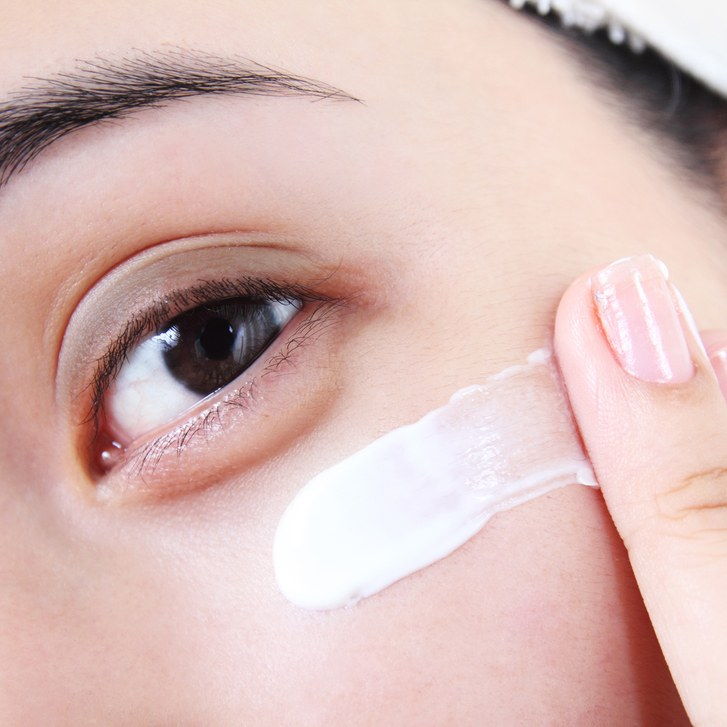 Едър план image of woman applying eye cream